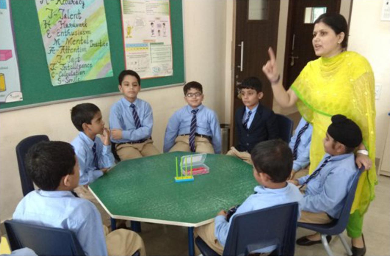 A teacher warmly listening to a student’s question in class, highlighting approachability, trust, open communication, and supportive learning